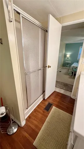a view of a hallway with wooden floor and door