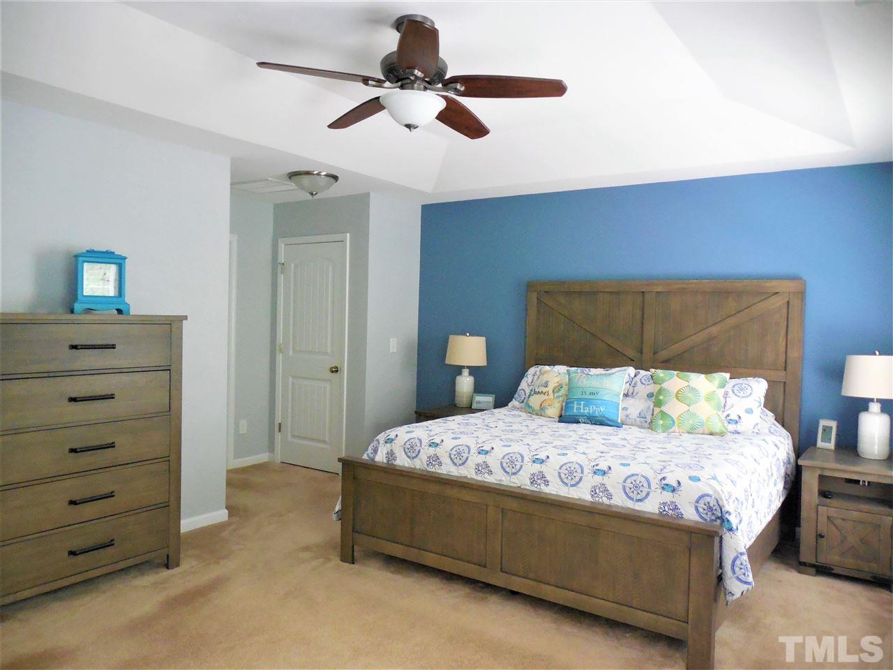 1235 Silver Beach Way Raleigh, NC 27606 - Photo 11 of 30 a bedroom with a bed a lamp and a dresser
