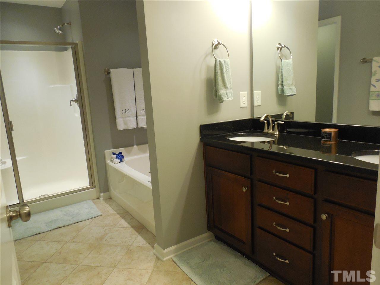1235 Silver Beach Way Raleigh, NC 27606 - Photo 12 of 30 a bathroom with a granite countertop sink a mirror and a shower