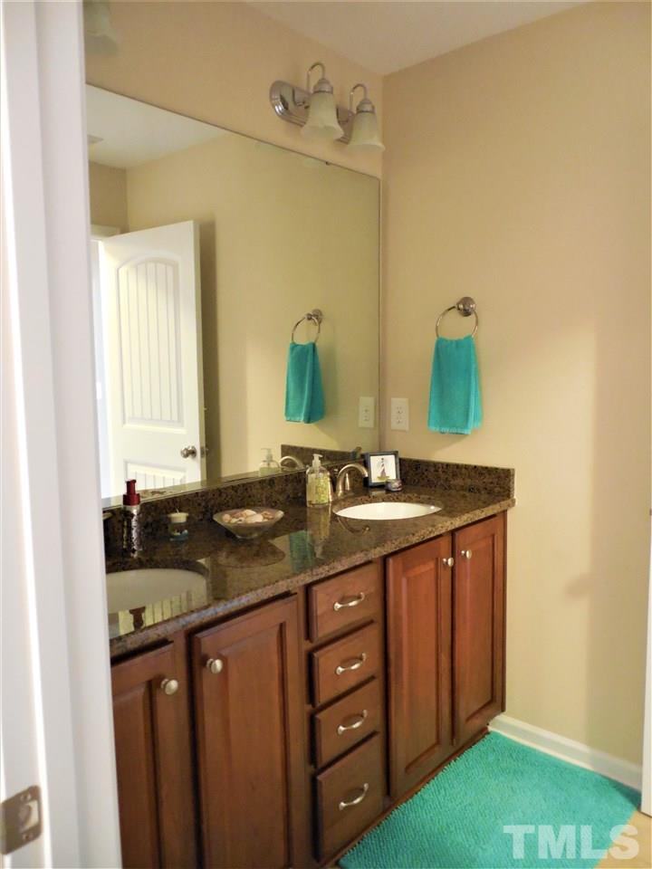 1235 Silver Beach Way Raleigh, NC 27606 - Photo 17 of 30 a bathroom with a granite countertop sink and a mirror