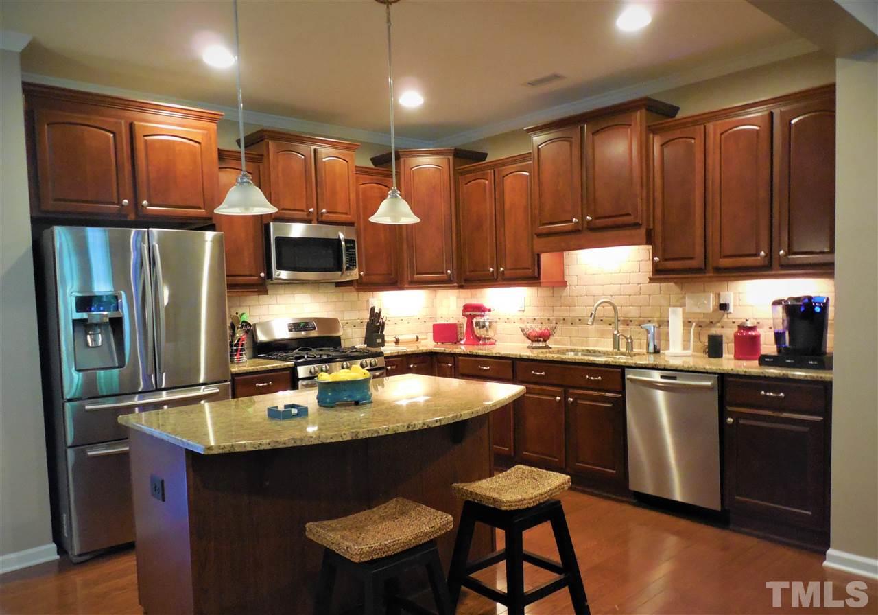 1235 Silver Beach Way Raleigh, NC 27606 - Photo 3 of 30 a kitchen with granite countertop a sink stove and refrigerator
