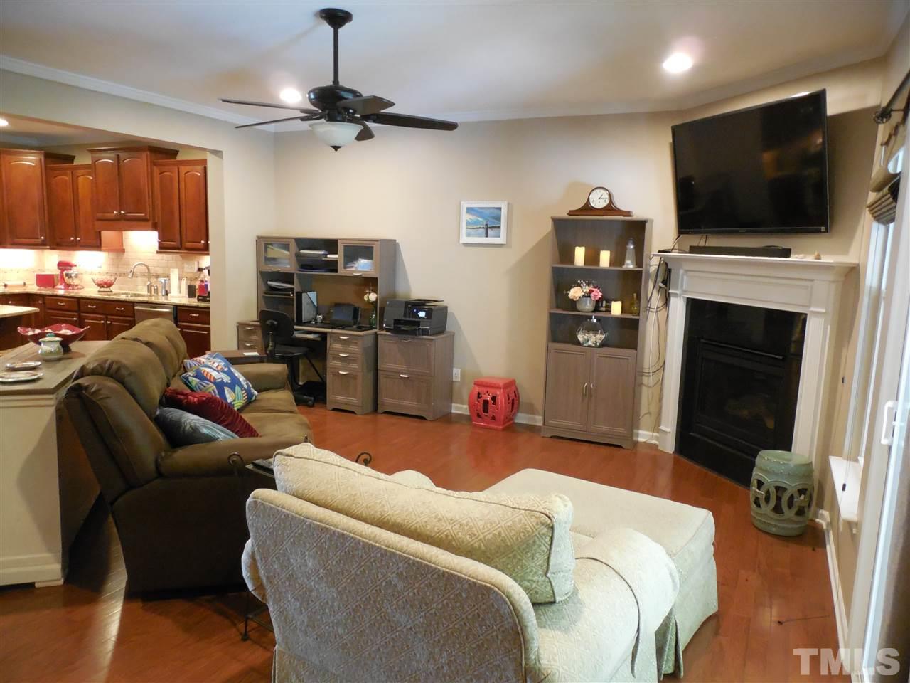 1235 Silver Beach Way Raleigh, NC 27606 - Photo 6 of 30 a living room with furniture a flat screen tv and a fireplace
