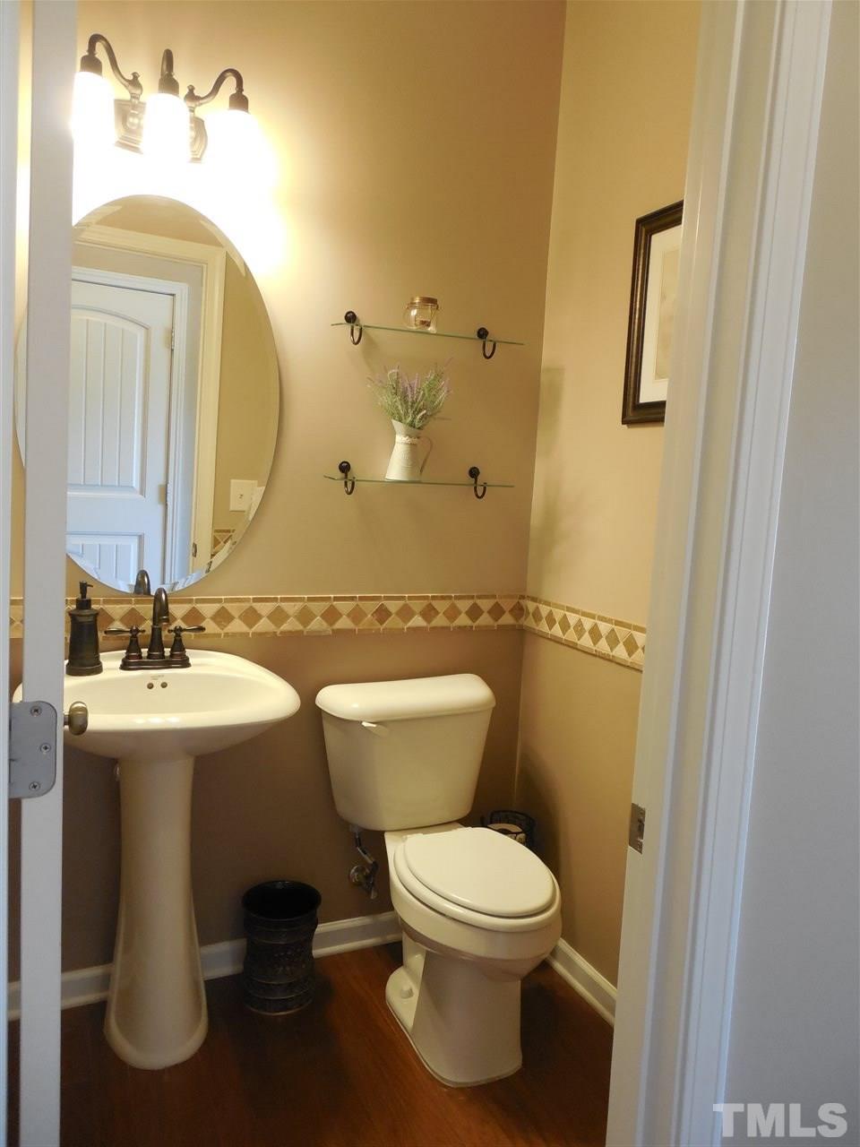 1235 Silver Beach Way Raleigh, NC 27606 - Photo 7 of 30 a bathroom with a toilet a sink and mirror