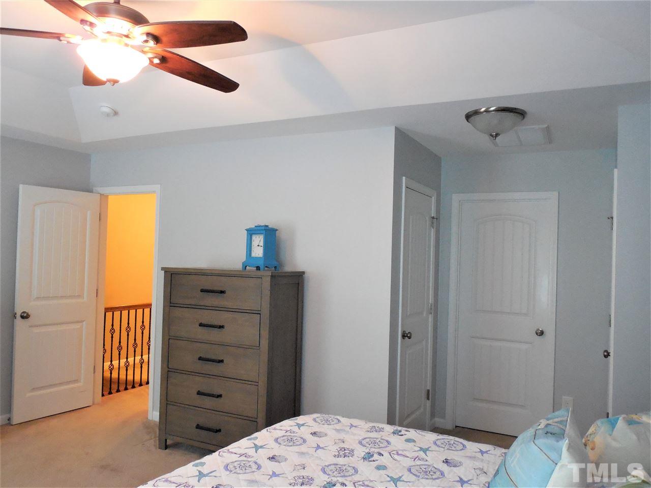 1235 Silver Beach Way Raleigh, NC 27606 - Photo 9 of 30 a bedroom with a dresser and a chandelier