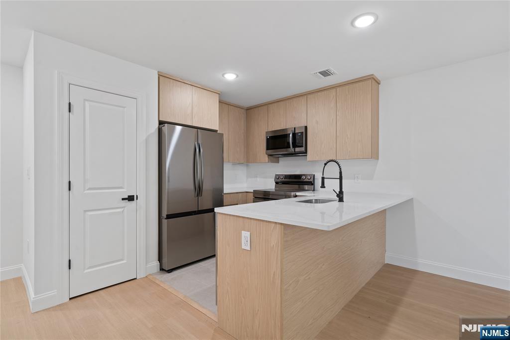 7 Montclair Avenue Paterson, NJ 07503 - Photo 15 of 26 a kitchen with kitchen island a sink appliances and cabinets