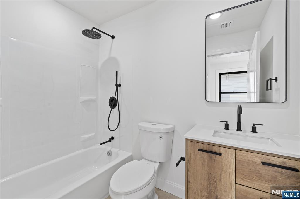 7 Montclair Avenue Paterson, NJ 07503 - Photo 19 of 26 a bathroom with a toilet sink vanity tub and shower