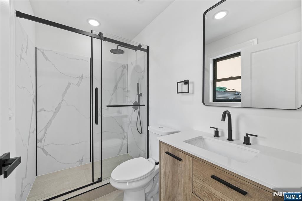 7 Montclair Avenue Paterson, NJ 07503 - Photo 23 of 26 a bathroom with a shower sink vanity mirror and toilet