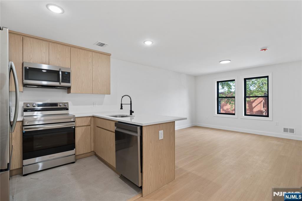 7 Montclair Avenue Paterson, NJ 07503 - Photo 3 of 26 a kitchen with stainless steel appliances granite countertop a sink and a stove top oven