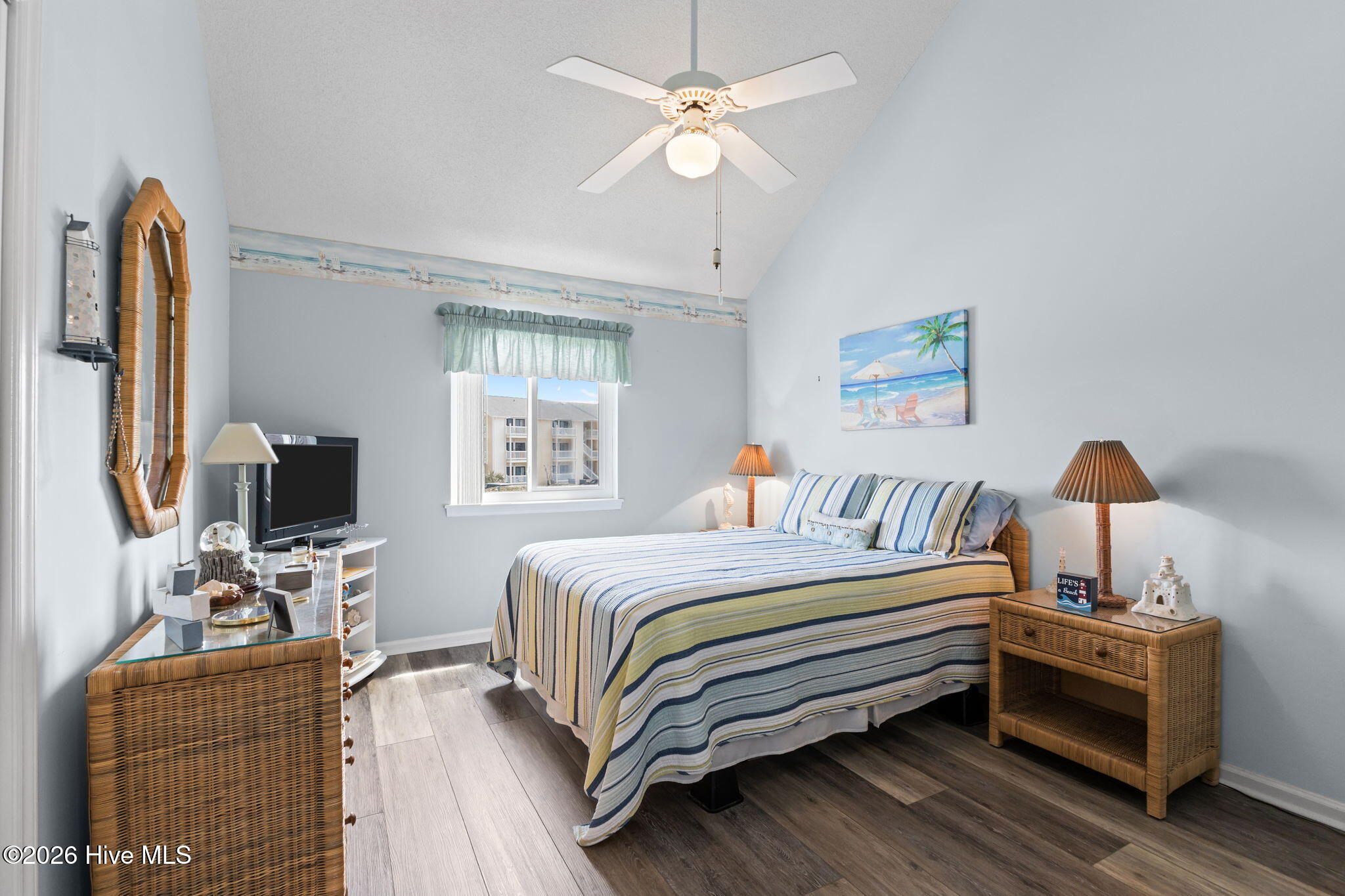 9201 Coast Guard Road, Unit I207 Emerald Isle, NC 28594 - Photo 11 of 26 Bedroom with vaulted ceilings, updated flooring, and soft natural light from the centered window. Neutral coastal-inspired décor creates a bright and relaxing atmosphere.