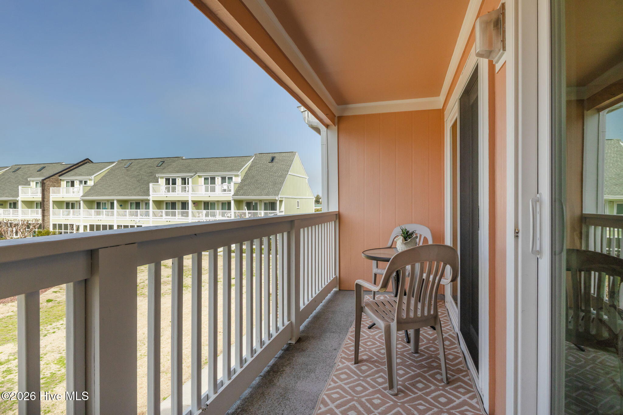 9201 Coast Guard Road, Unit I207 Emerald Isle, NC 28594 - Photo 16 of 26 Covered balcony with seating area overlooking the surrounding community. Ideal space for enjoying outdoor relaxation and fresh air.