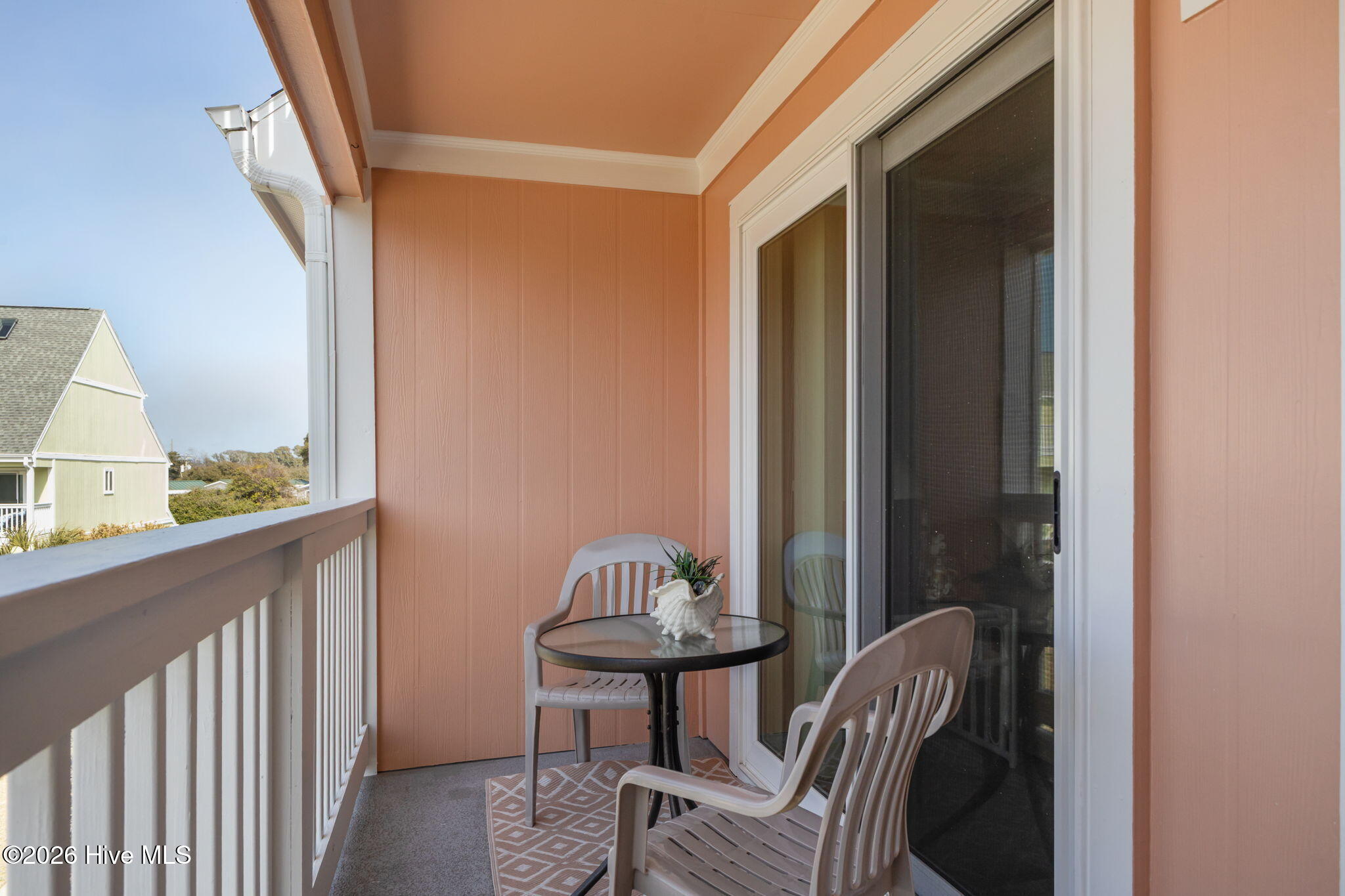 9201 Coast Guard Road, Unit I207 Emerald Isle, NC 28594 - Photo 4 of 26 Private covered balcony featuring sliding glass door access from the living area. Compact outdoor seating area provides an additional space to unwind.