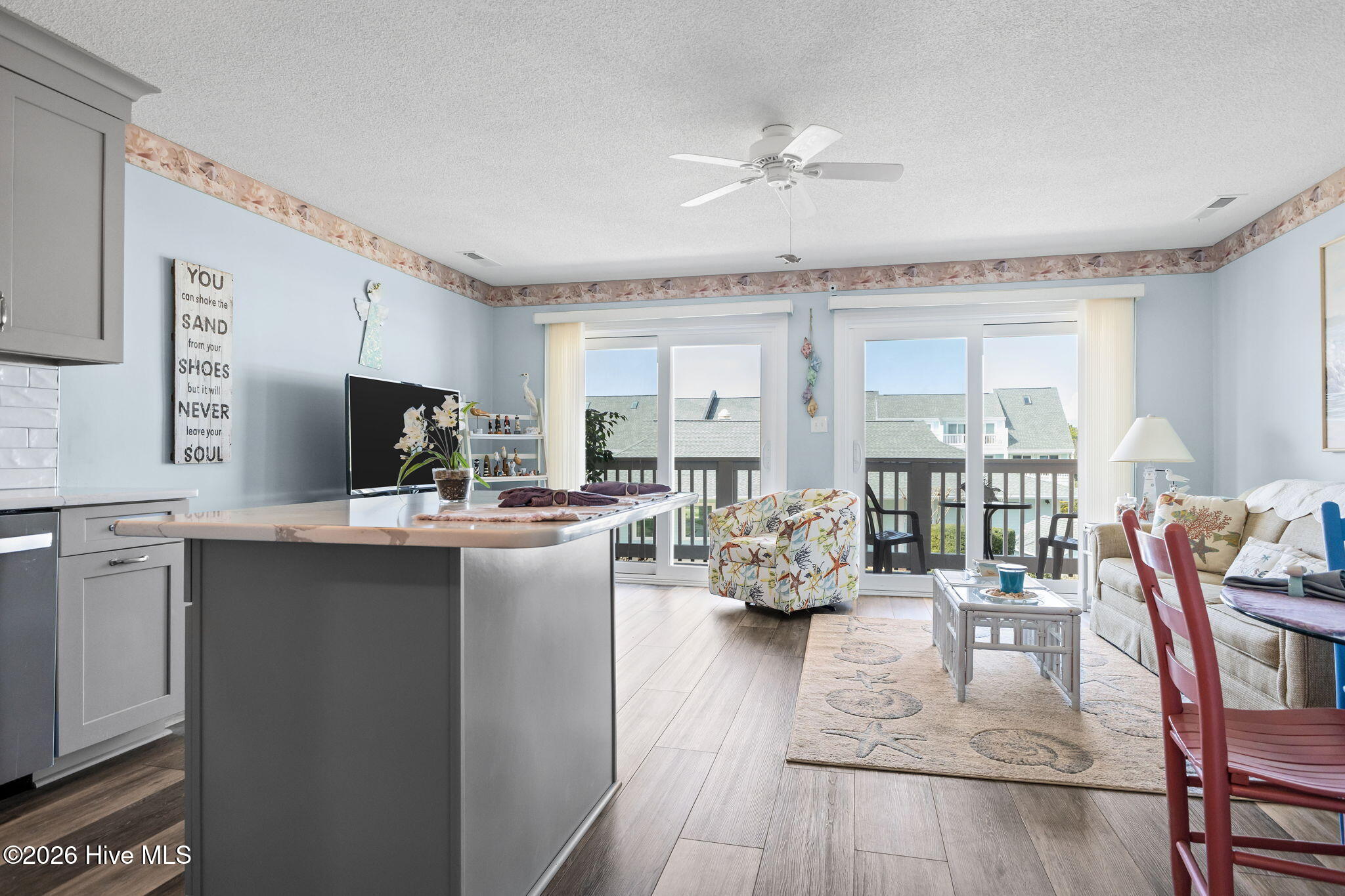 9201 Coast Guard Road, Unit I207 Emerald Isle, NC 28594 - Photo 7 of 26 Open-concept living and dining area with large sliding glass doors leading to the balcony. Durable flooring and abundant natural light enhance the spacious feel.
