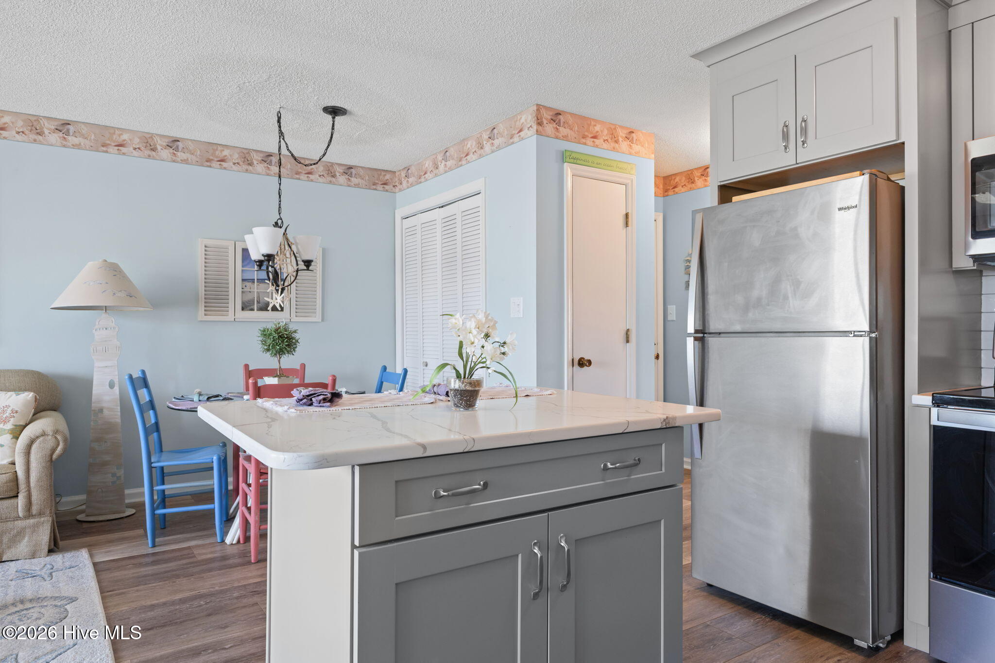 9201 Coast Guard Road, Unit I207 Emerald Isle, NC 28594 - Photo 8 of 26 Kitchen with oversized island, ample cabinet storage, and adjacent dining space for casual meals or entertaining. Updated finishes provide a clean, modern look.