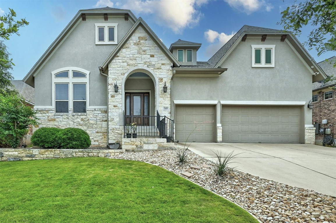 a front view of a house with a garden and yard