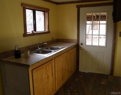 536 Riverside Avenue Sugarloaf, CA 92386 - Photo 5 of 12 Kitchen. Step-saver kitchen with tile countertop and door leading to back deck.