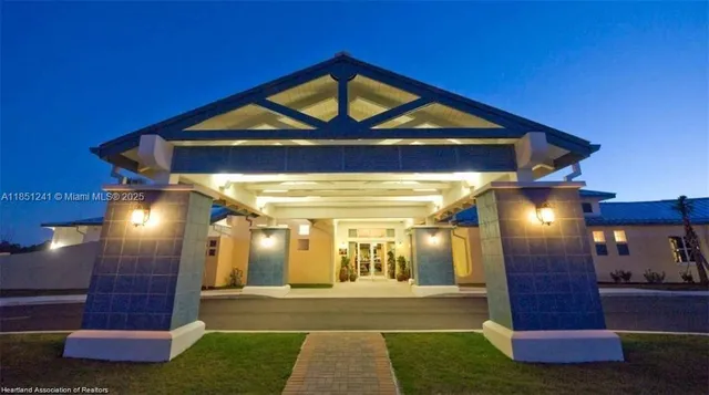 a sign that is sitting in the grass near a building