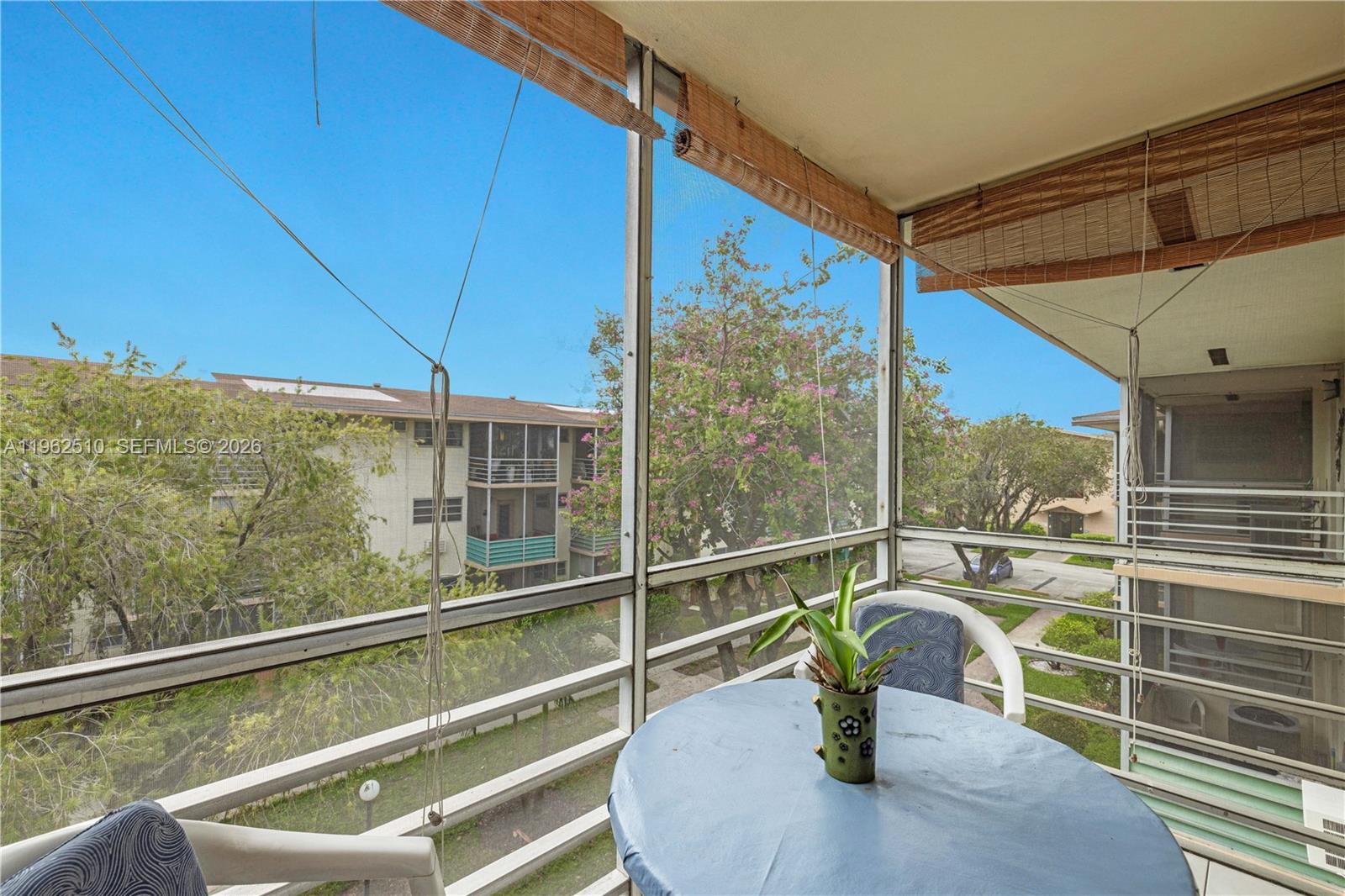 16750 Northeast 14th Avenue, Unit 308 Miami, FL 33162 - Photo 15 of 29 a view of a balcony with dining table and chairs