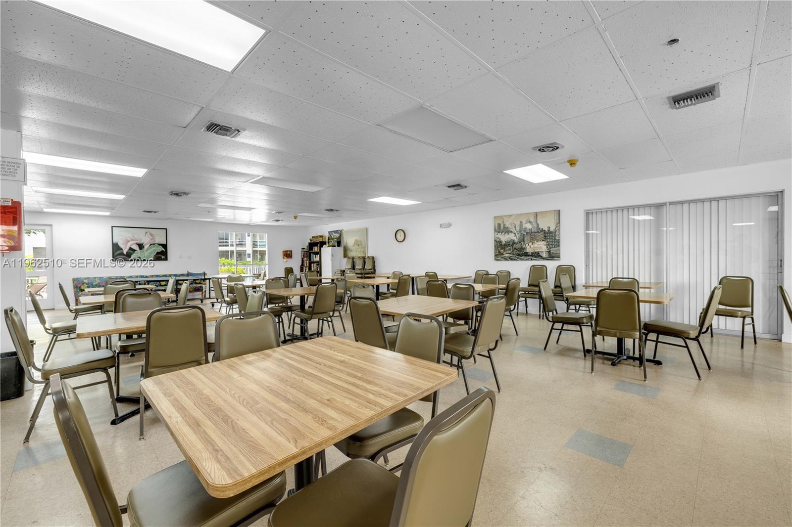 16750 Northeast 14th Avenue, Unit 308 Miami, FL 33162 - Photo 23 of 29 a room with lots of chairs a table and chairs in it