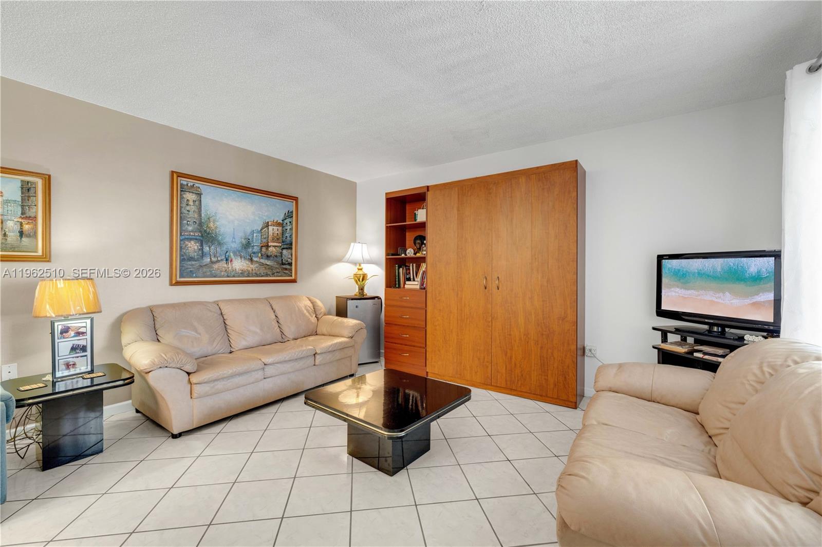 16750 Northeast 14th Avenue, Unit 308 Miami, FL 33162 - Photo 3 of 29 a living room with furniture and a flat screen tv
