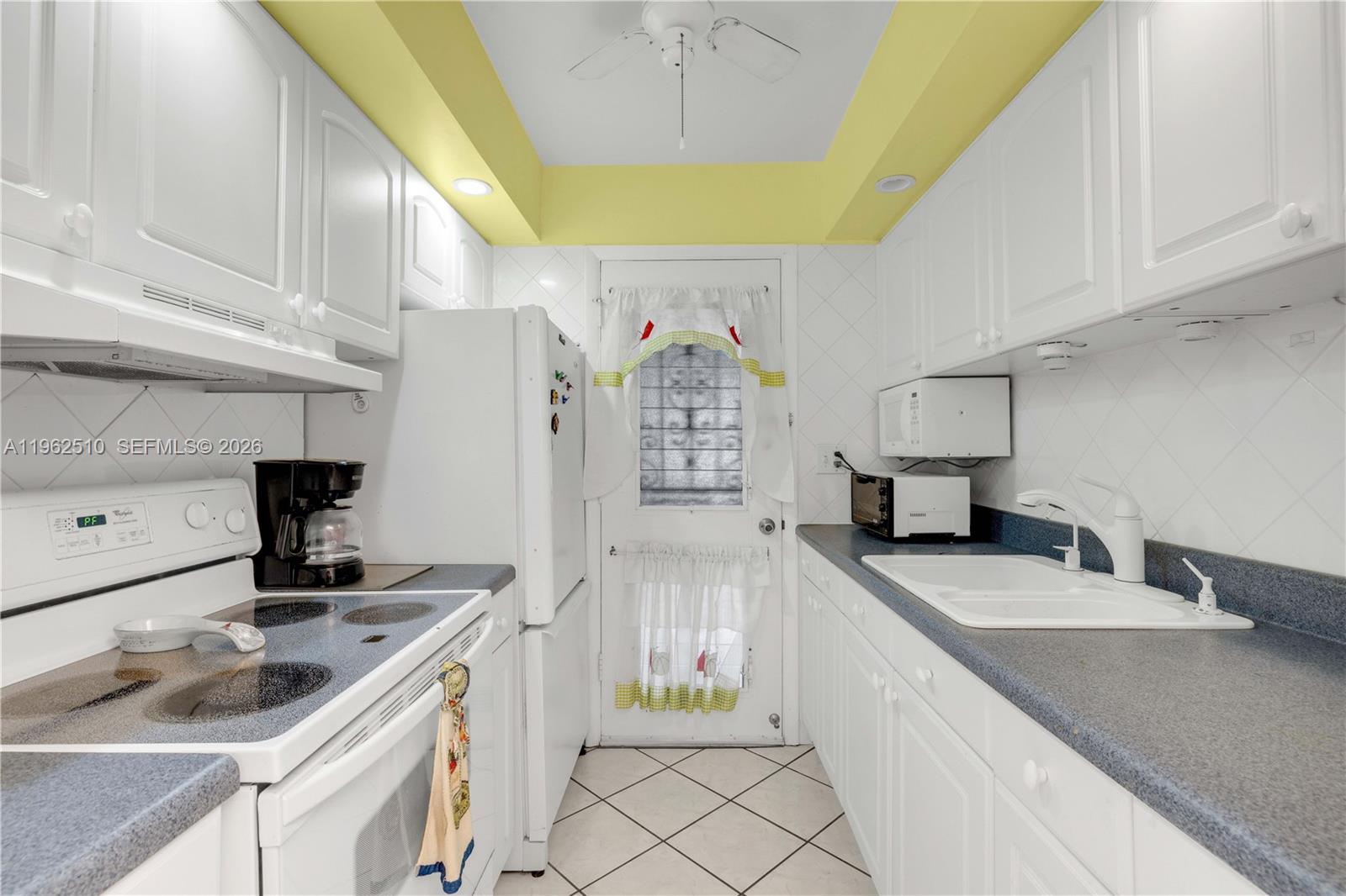 16750 Northeast 14th Avenue, Unit 308 Miami, FL 33162 - Photo 8 of 29 a kitchen with granite countertop a sink and a stove top oven