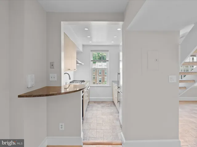 a large white kitchen with a sink and dishwasher a refrigerator with white cabinets