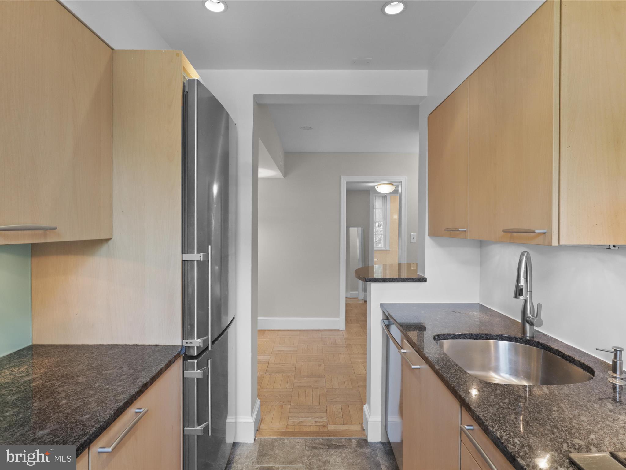 2721 Ordway Street Northwest, Unit 5 Washington, DC 20008 - Photo 16 of 39 a kitchen with granite countertop a sink and a refrigerator