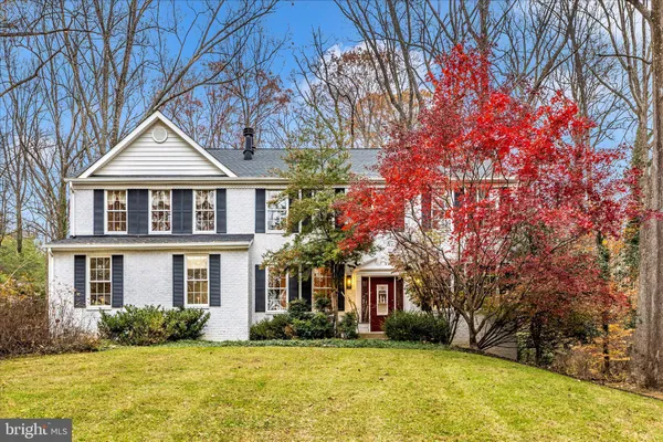 a front view of house with yard and trees around