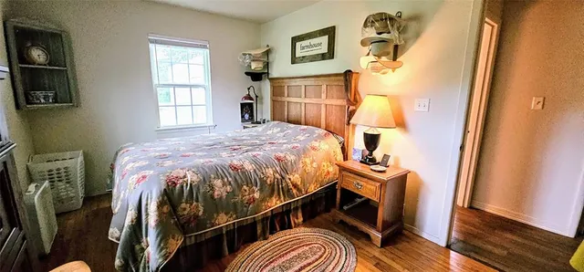 a bedroom with bed and wooden floor