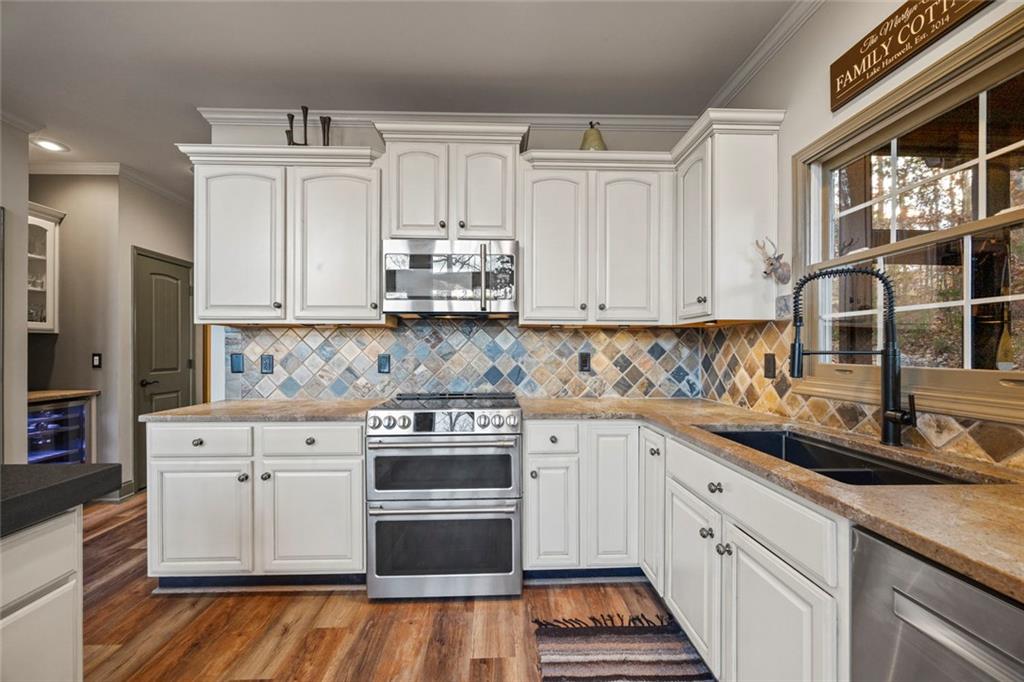 152 Chapman Manor Drive Martin, GA 30557 - Photo 29 of 90 a kitchen with stainless steel appliances granite countertop a stove a sink and white cabinets