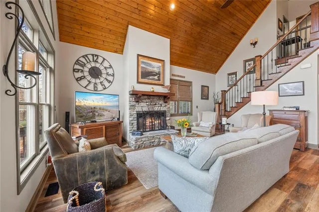 a living room with furniture a flat screen tv and a large window