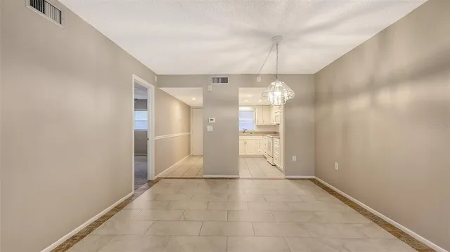 an empty room with windows and ceiling fan