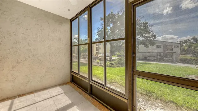 an empty room with a window and a fan