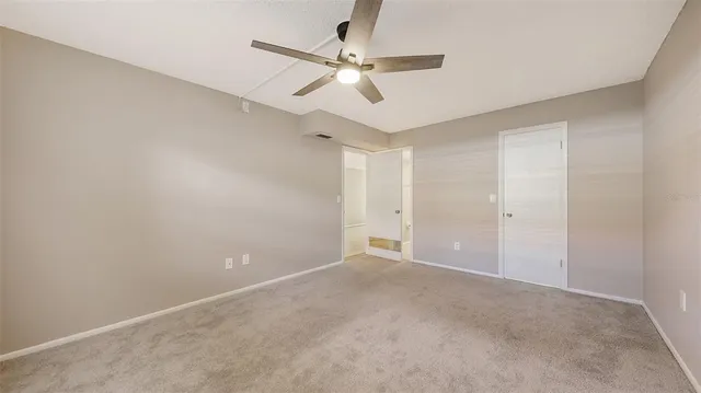 an empty room with a window and a fan