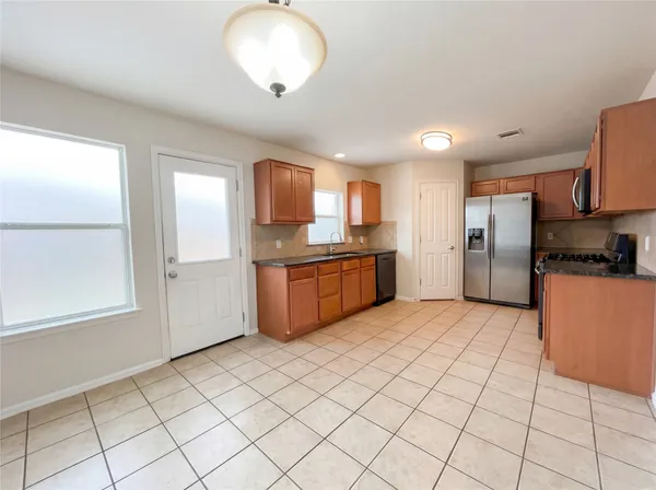 a kitchen with stainless steel appliances granite countertop a refrigerator and a stove top oven