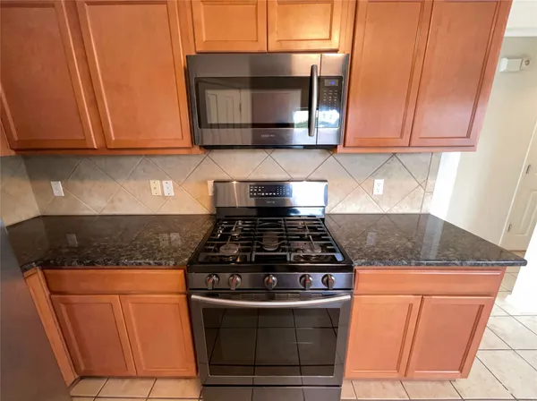 a kitchen with granite countertop wood cabinets and stainless steel appliances