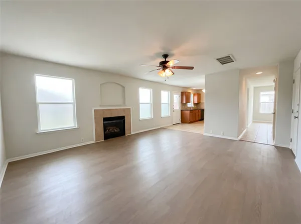 an empty room with windows and fireplace