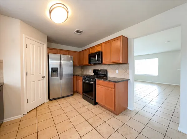 a kitchen with stainless steel appliances granite countertop a refrigerator and a sink