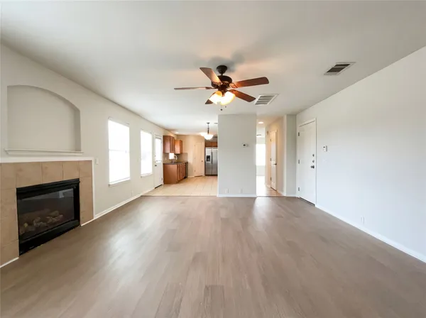 a view of an empty room with a fireplace and a window