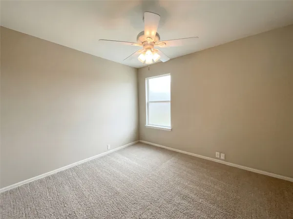 an empty room with a window and a fan