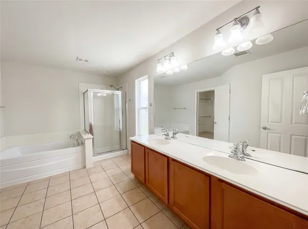 a spacious bathroom with a double vanity sink a mirror and a bathtub