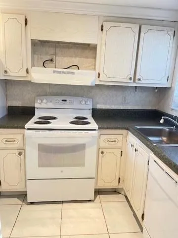 a kitchen with granite countertop white cabinets and white appliances