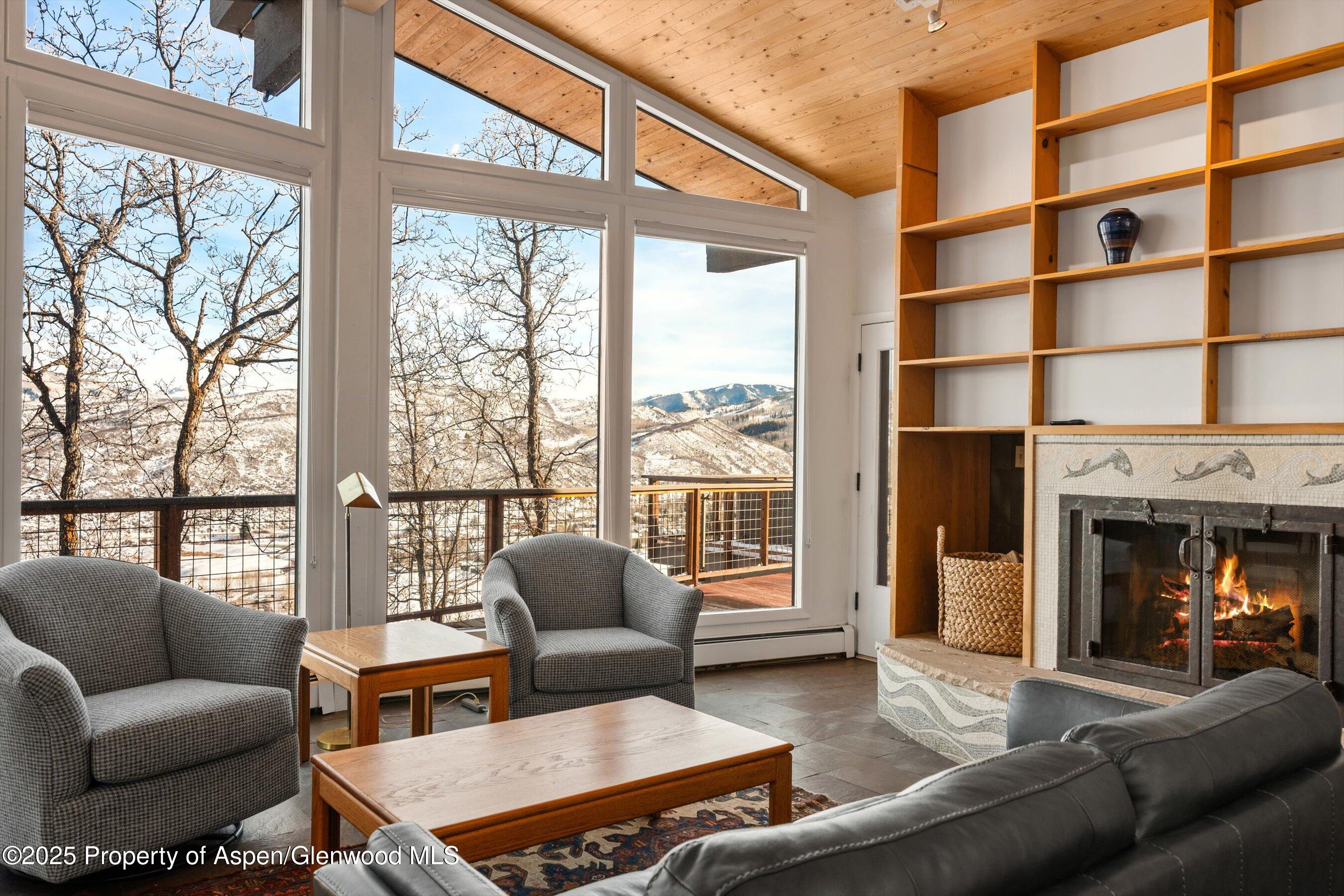 328 Oak Ridge Road Snowmass Village, CO 81615 - Photo 11 of 44 a living room with furniture a floor to ceiling windows and a fireplace