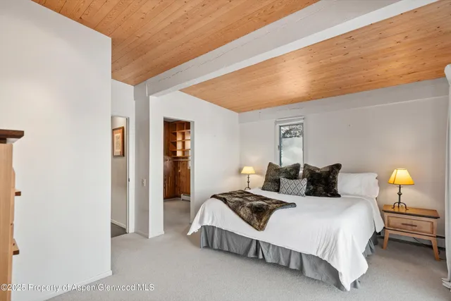 a spacious bedroom with a bed and a lamp