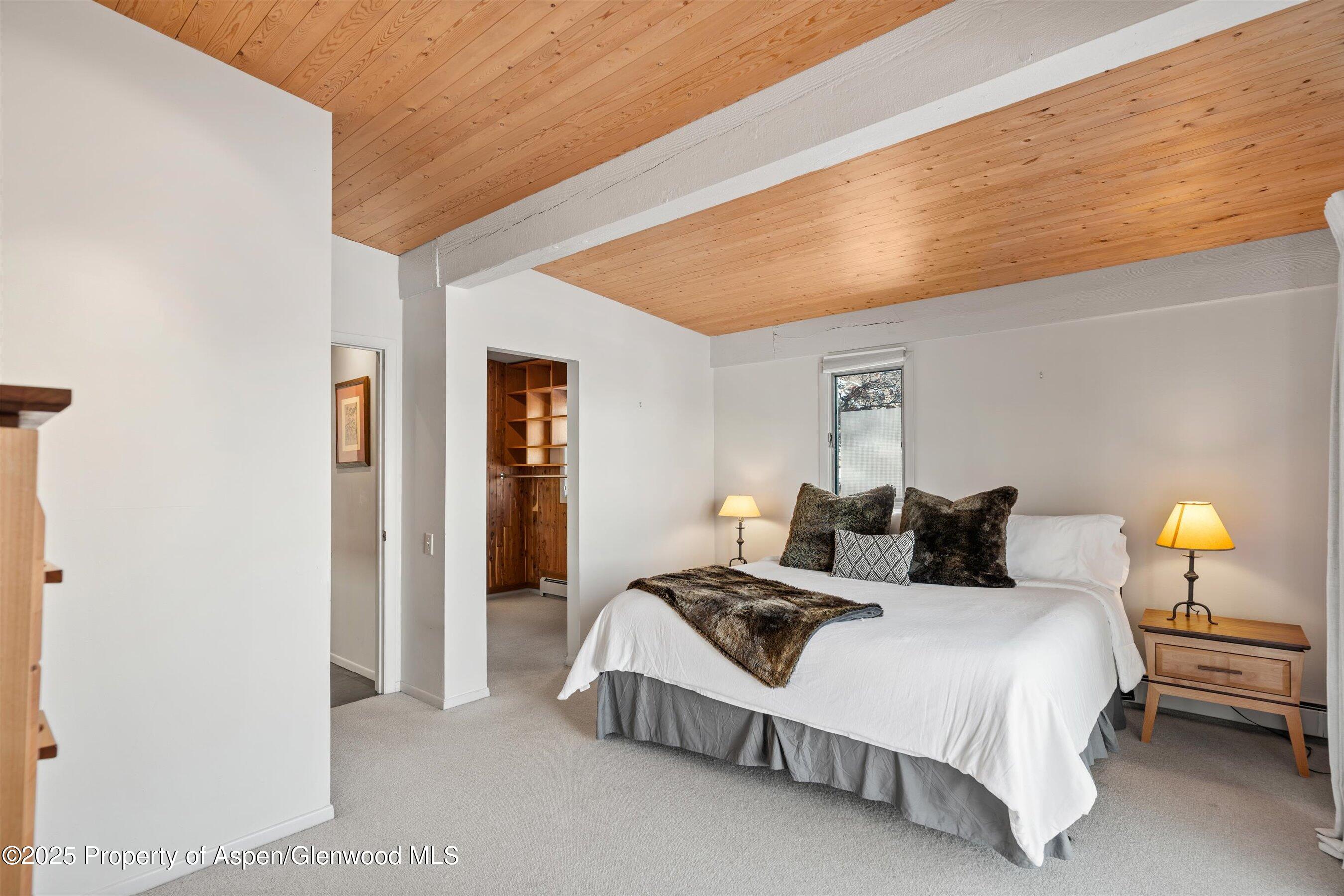 328 Oak Ridge Road Snowmass Village, CO 81615 - Photo 17 of 44 a spacious bedroom with a bed and a lamp