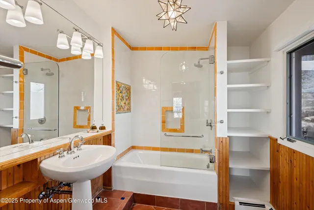 a bathroom with a sink mirror and a bathtub