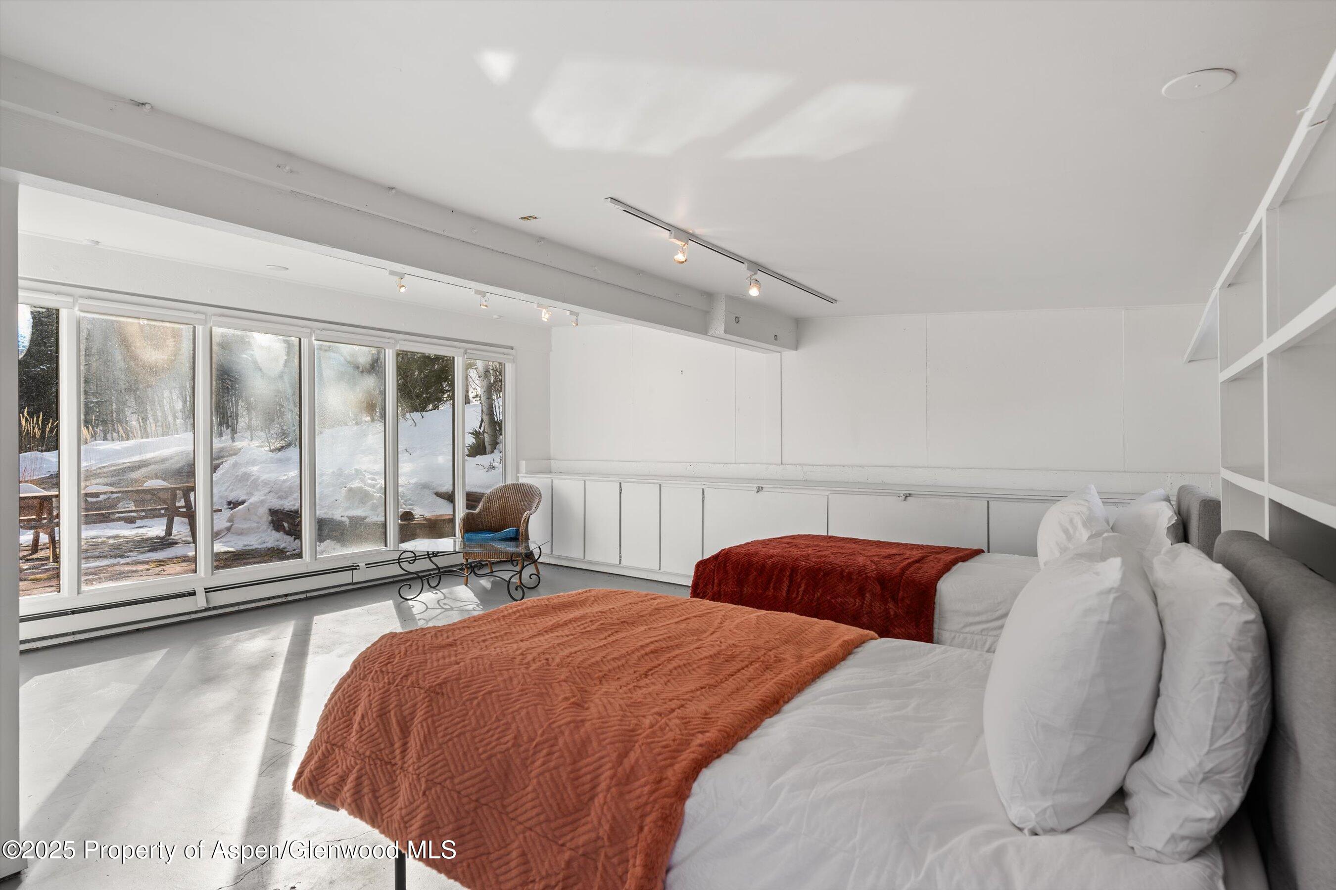 328 Oak Ridge Road Snowmass Village, CO 81615 - Photo 33 of 44 a bedroom with bed and glass door