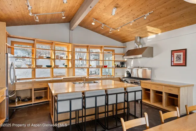a dining room with stainless steel appliances a table and chairs