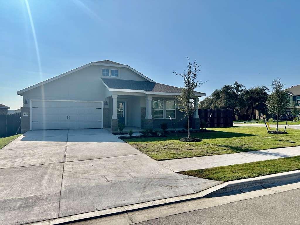 Craftsman-style home featuring stucco siding, driveway, a garage, and covered porch