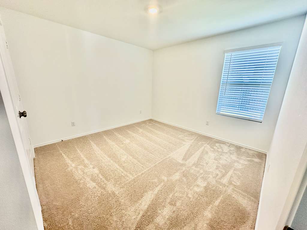 4104 Home Pl Road Georgetown, TX 78628 - Photo 11 of 35 Spare room with light colored carpet and baseboards