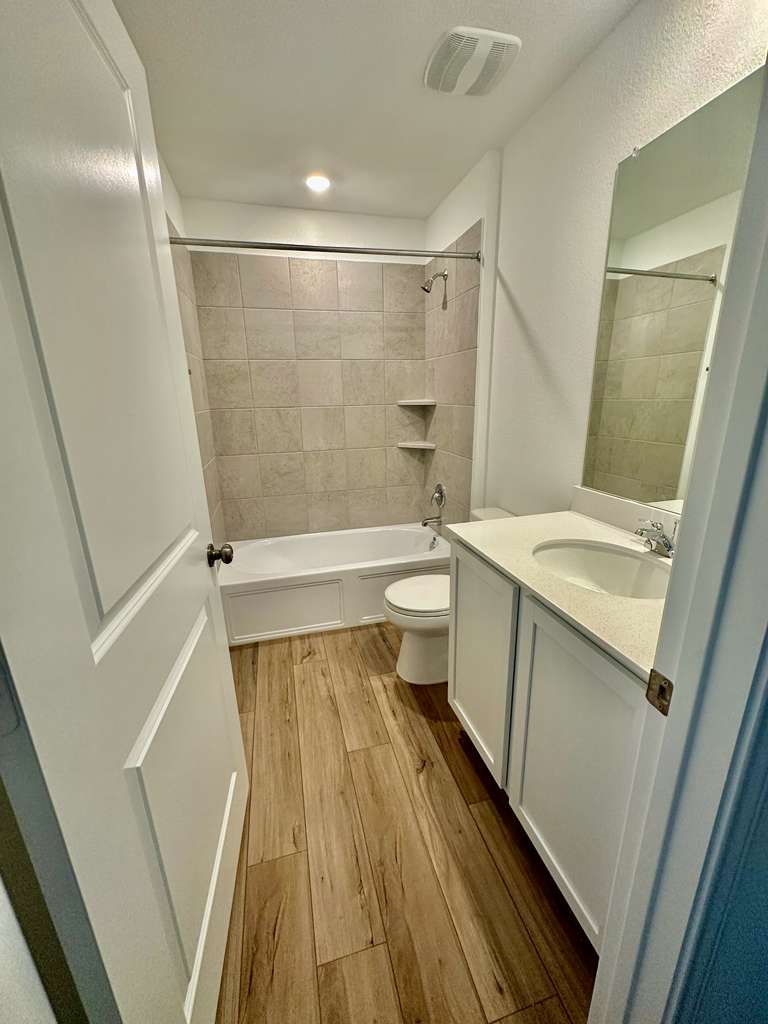 4104 Home Pl Road Georgetown, TX 78628 - Photo 12 of 35 Full bath featuring vanity, dark wood-type flooring, and shower / washtub combination